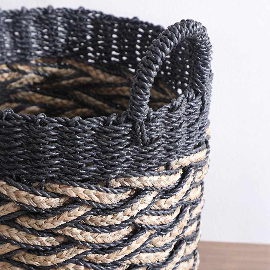 black and natural braided storage basket, handwoven basket with handles, two-tone woven rope basket, eco-friendly seagrass basket, 
decorative jute and black fiber basket, close-up of handwoven basket craftsmanship, modern rustic woven storage bin, braided seagrass rope basket for décor, durable handwoven laundry hamper, artisan-style black basket with details.