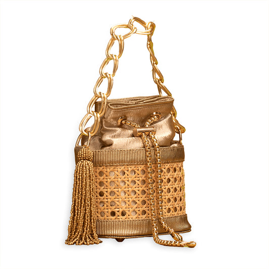Luxury designer bucket bag, Golden evening handbag, Woven rattan handbag, Gold chain handle purse, Glamorous drawstring bag, Handcrafted rattan bag, Gold embellished clutch bag, Elegant party bag for women, Designer cane bag with tassel, Boutique artisan handbag, Handcrafted golden bucket bag with chain strap and rattan weave, Designer party handbag with gold accents and tassel, Woven cane purse with metallic gold drawstring closure .