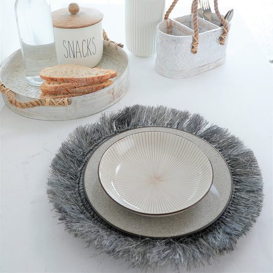 Grey fringe placemat, Boho style table mat, Textured table placemat,
Decorative charger mat, Woven placemat with fringe, Rustic dining table accessory, Shaggy edge table mat, Handcrafted round placemat,
Stoneware dinner plate, Minimalist ceramic bowl, Modern dinnerware set, Textured ceramic plates, Reactive glaze plate set, Handmade ceramic dishware, Beige and brown dish set, Rustic kitchen ceramics.