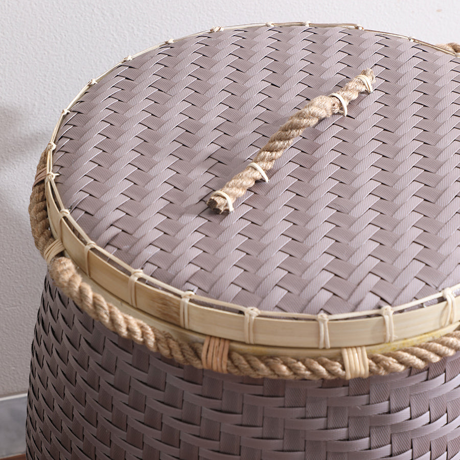 Woven storage basket with rope handle, Brown plastic wicker basket, 
Handmade basket with lid, Rattan-look storage bin, Rustic woven hamper, Durable synthetic wicker basket, Rope handle laundry basket, Bamboo rim storage basket, Close-up of woven plastic texture, Handcrafted plastic wicker basket, Braided rope and bamboo trim bin, Natural finish synthetic basket.