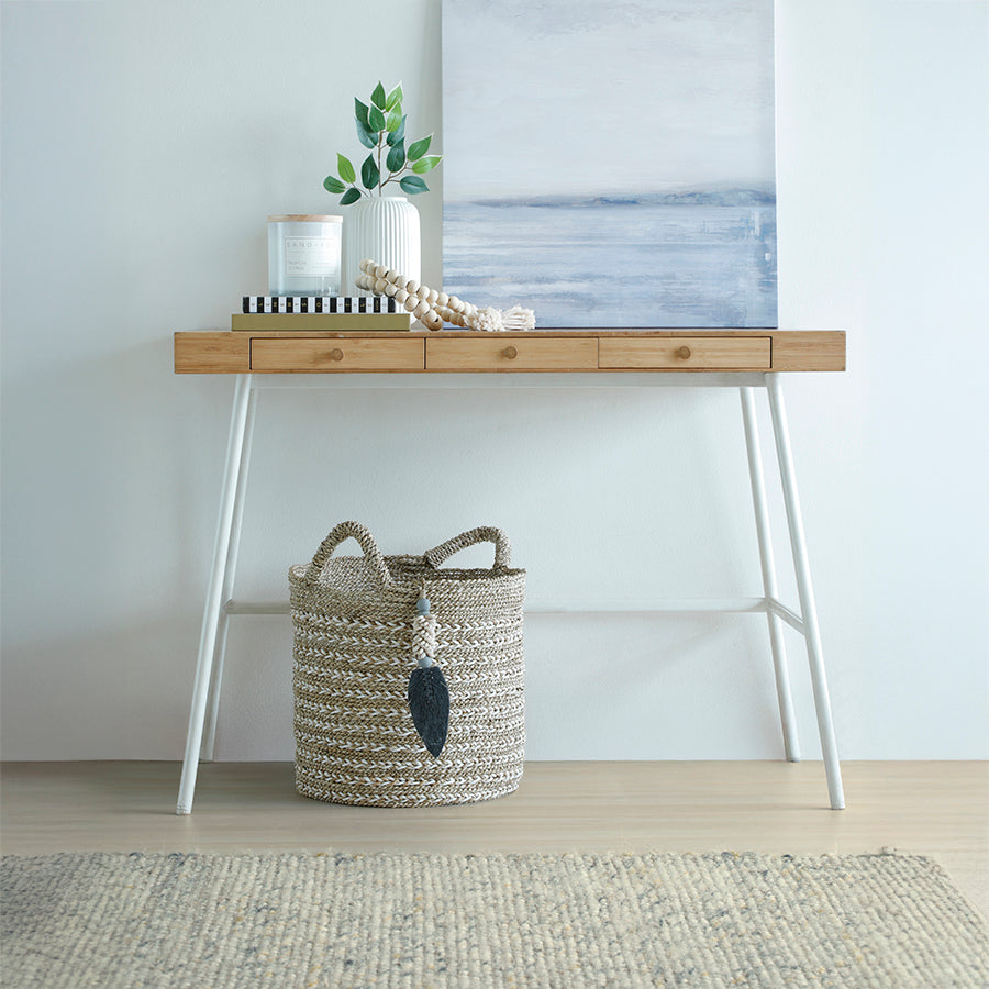 Twisted weave seagrass basket, 
Decorative woven basket with tassel, 
Two-tone jute storage basket, 
Handwoven basket with handles, 
Natural fiber basket with charm, 
Hand-braided basket with tassel décor, White and natural woven basket for entryway, Rustic jute storage bin with handles, Seagrass basket for console or hallway décor, 
Eco-friendly handcrafted basket.