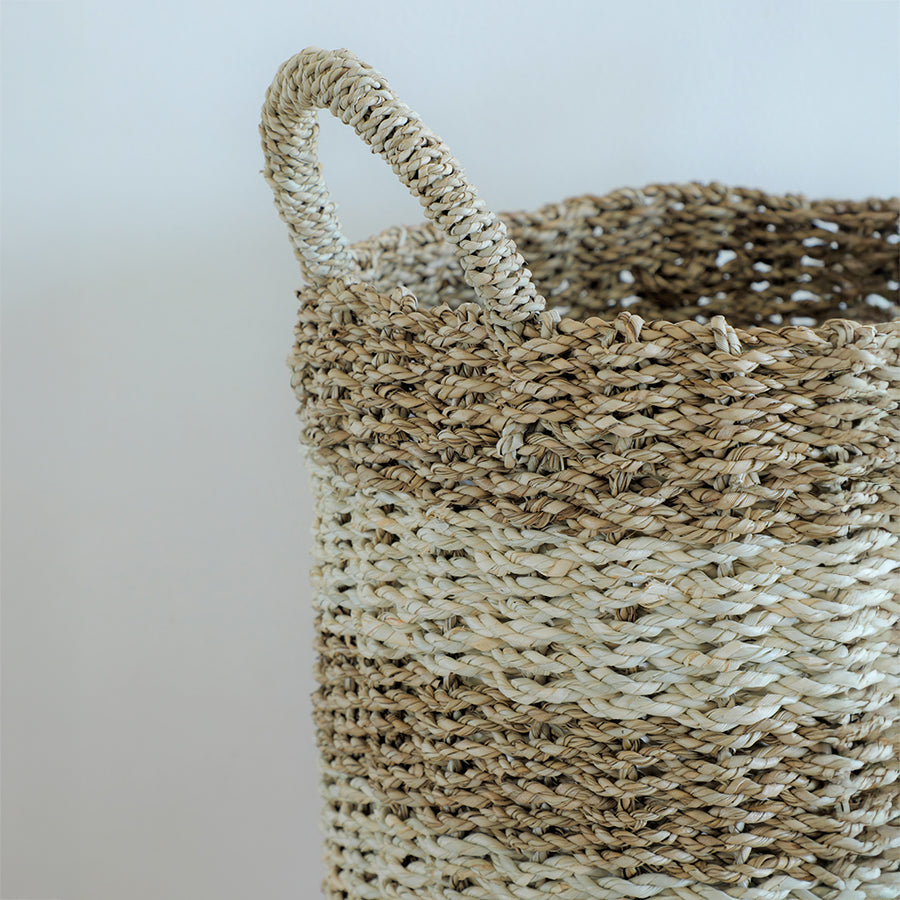 Two-tone woven basket, Handwoven seagrass basket, Natural fiber storage basket, Jute and straw decorative basket, Basket with handles, Close-up of handcrafted woven basket, Rustic two-tone storage basket for home, Eco-friendly natural storage solution, Hand-braided basket for organizing,
Farmhouse décor woven basket with handle.