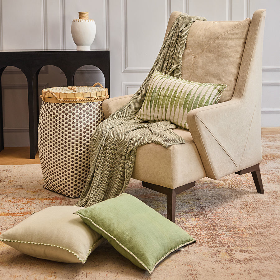 Woven storage basket with lid, Tall decorative laundry hamper, Handcrafted basket with bamboo and rope, Stylish lidded basket for living room, Brown and cream woven hamper, Modern beige upholstered armchair, High-back accent chair for living room, Comfortable fabric armchair with wooden legs, Contemporary lounge chair for home décor, Soft padded reading chair.