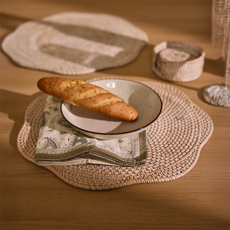 wavy rattan placemat, woven charger plate, Boho natural placemat, handcrafted rattan table mat, organic dining placemat, striped ceramic bowl, modern serving bowl, white stoneware bowl, artisan ceramic dish, minimalist tableware, paisley print cloth napkin, reusable cotton napkin, eco-friendly dining napkin, farmhouse style napkin, soft cotton table napkin, artisan bread serving,
rustic bread display, baguette table styling .