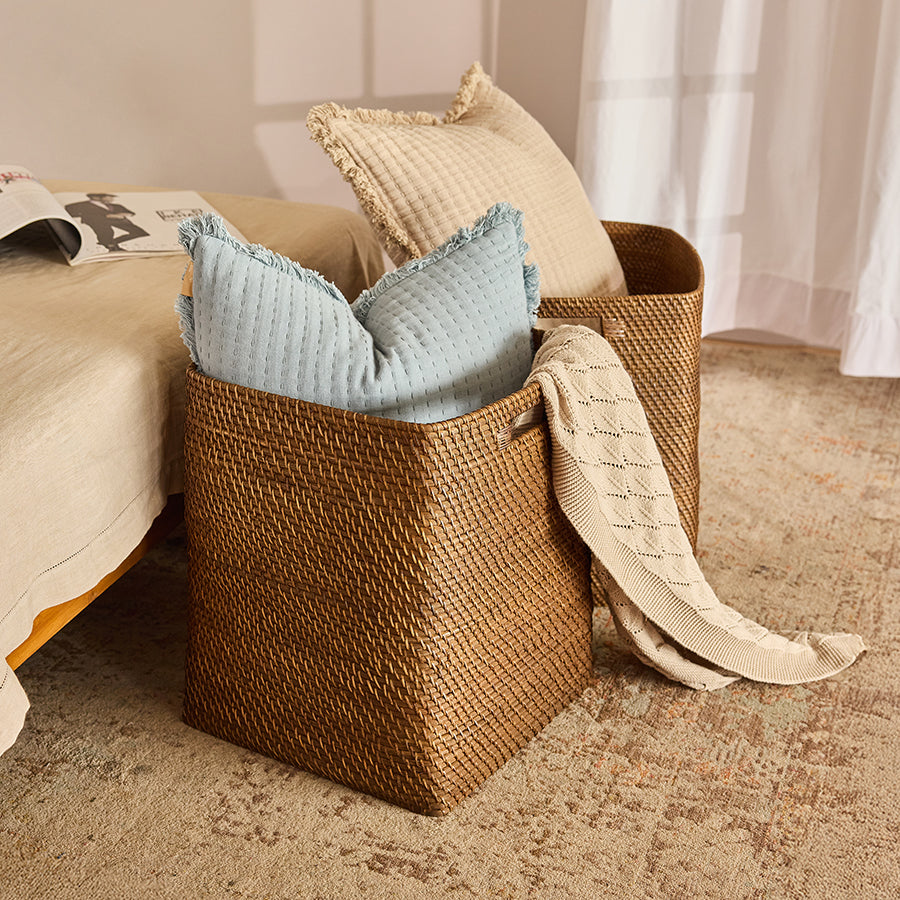Woven storage basket, Rattan basket with handles, Handwoven wicker bin, Square wicker basket, Decorative storage basket, Woven basket for pillows and throws, Handcrafted rattan basket for bedroom, Large basket for home organization, Stylish wicker storage for linens, Natural fiber basket for cozy décor.