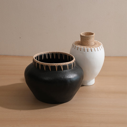 black clay pot with rattan detail, 
handcrafted black tribal vase, 
bohemian black pottery décor, white ceramic vase with wicker neck, 
handmade white decorative pot, 
minimalist white tribal vase, Boho decorative vase set, handmade pottery duo, ethnic pottery home décor set. 