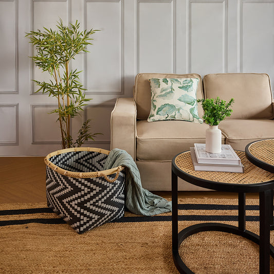 Black and natural woven basket, Modern zigzag pattern storage basket, Decorative woven bin with handles, Modern Boho living room décor, Cozy living room storage solutions, Indoor artificial bamboo plant, Textured area jute rug, 
Round rattan and black coffee table.
