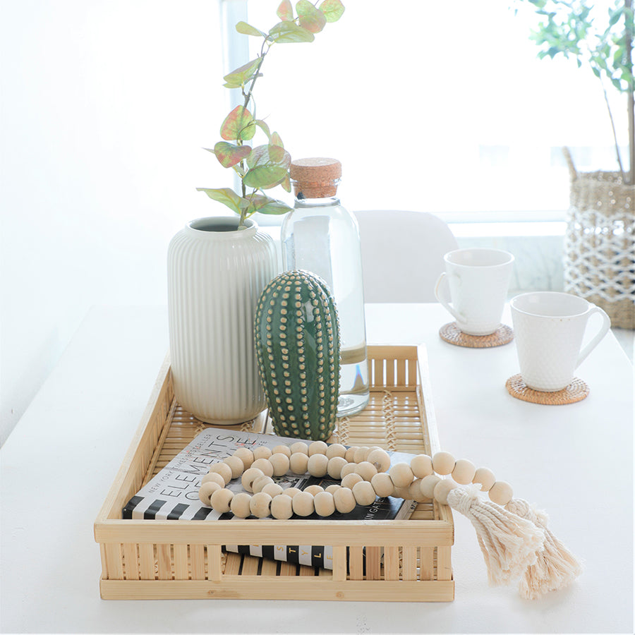Bamboo serving tray, Natural woven tray with handles, Eco-friendly kitchen tray, Handcrafted bamboo tray, Rectangular breakfast tray, 
White ribbed ceramic vase, Modern vase with artificial plant, Minimalist home vase décor, Decorative ceramic vase, Faux eucalyptus vase .


