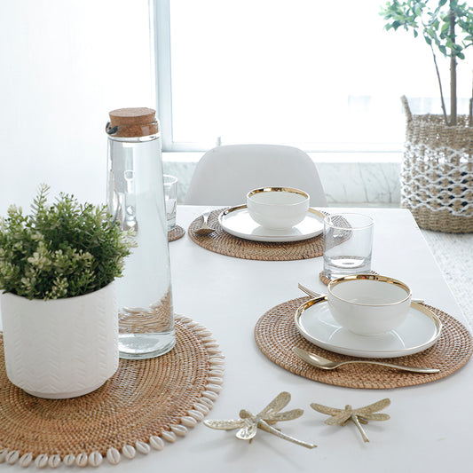 Natural rattan placemats, Round woven placemats, Handcrafted rattan table mats, Boho dining placemats, Eco-friendly table setting mats, Decorative shell placemat, Rattan placemat with shell border, Coastal Boho placemat, Beach-themed table décor, Handwoven shell-edge table mat .

